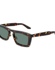 Sunglasses with tortoiseshell frame and green lenses on a light gray background. - De Duchi