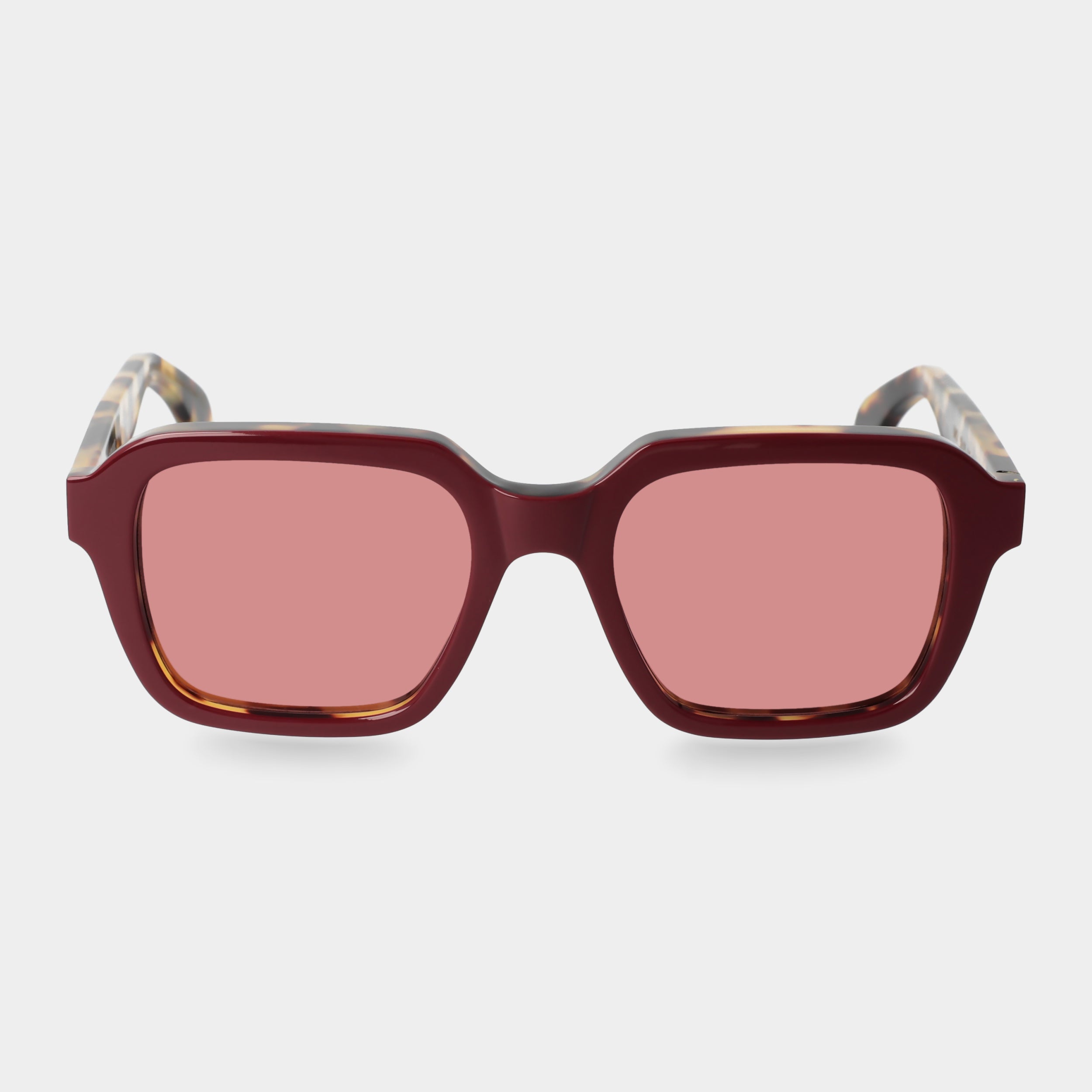 Sunglasses with red-tinted lenses on a light gray background. - Dei Duchi