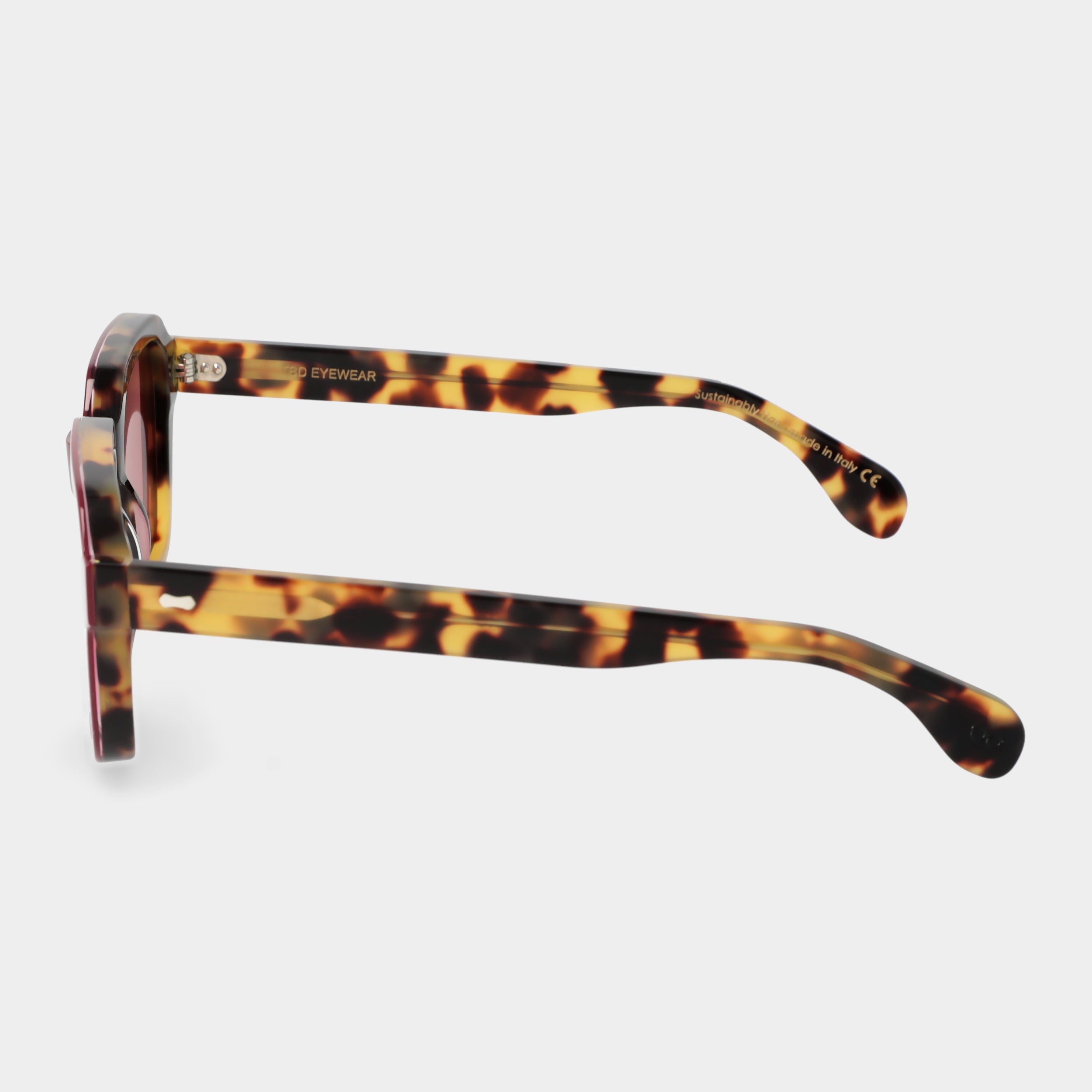 Sunglasses with red-tinted lenses on a light gray background. - Dei Duchi
