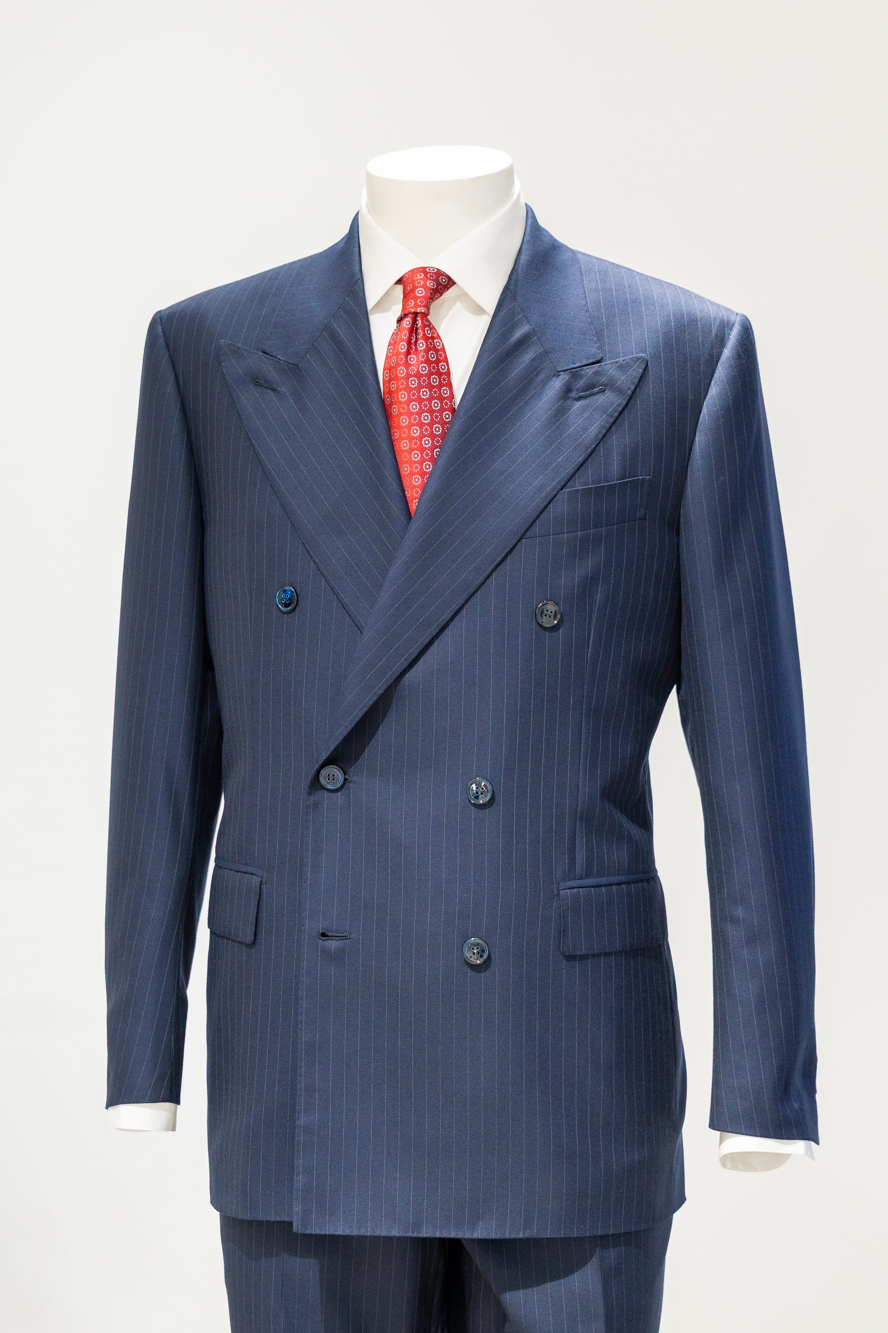 Blue pinstripe suit with a red tie on a mannequin against a white background. - Sartoria Dei Duchi-Atri