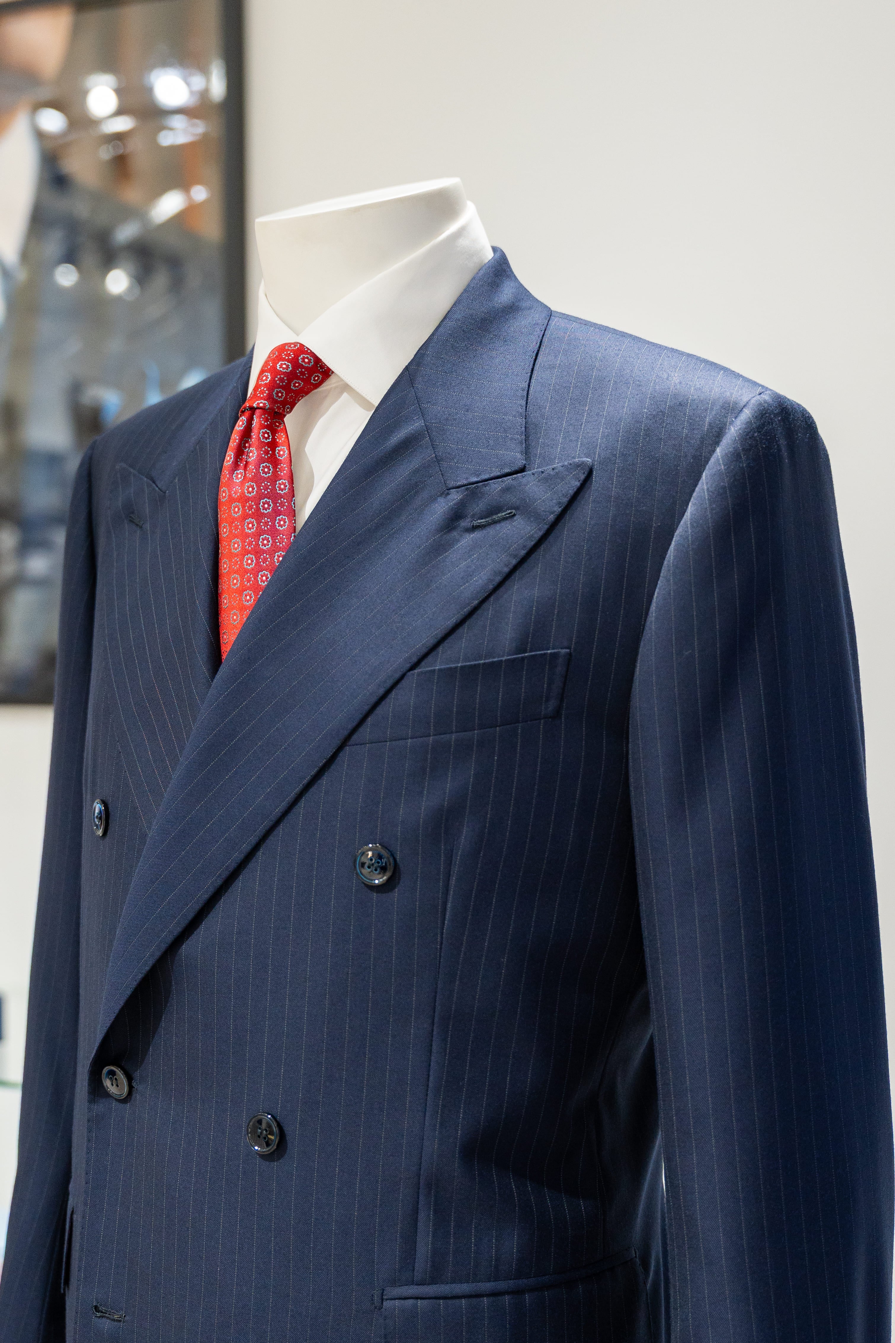 Blue pinstripe suit with a red tie on a mannequin against a white background. - Sartoria Dei Duchi-Atri