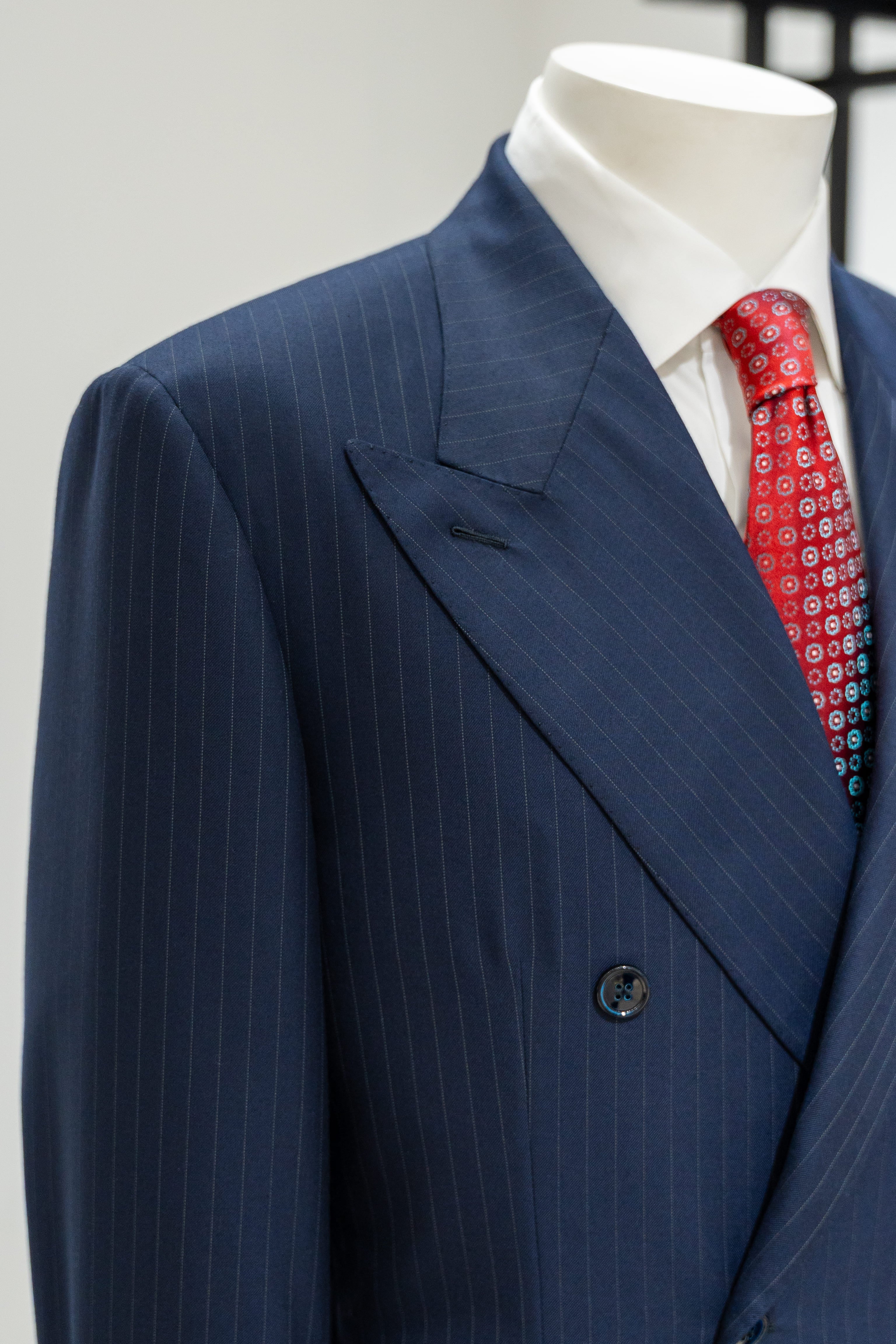 Blue pinstripe suit with a red tie on a mannequin against a white background. - Sartoria Dei Duchi-Atri