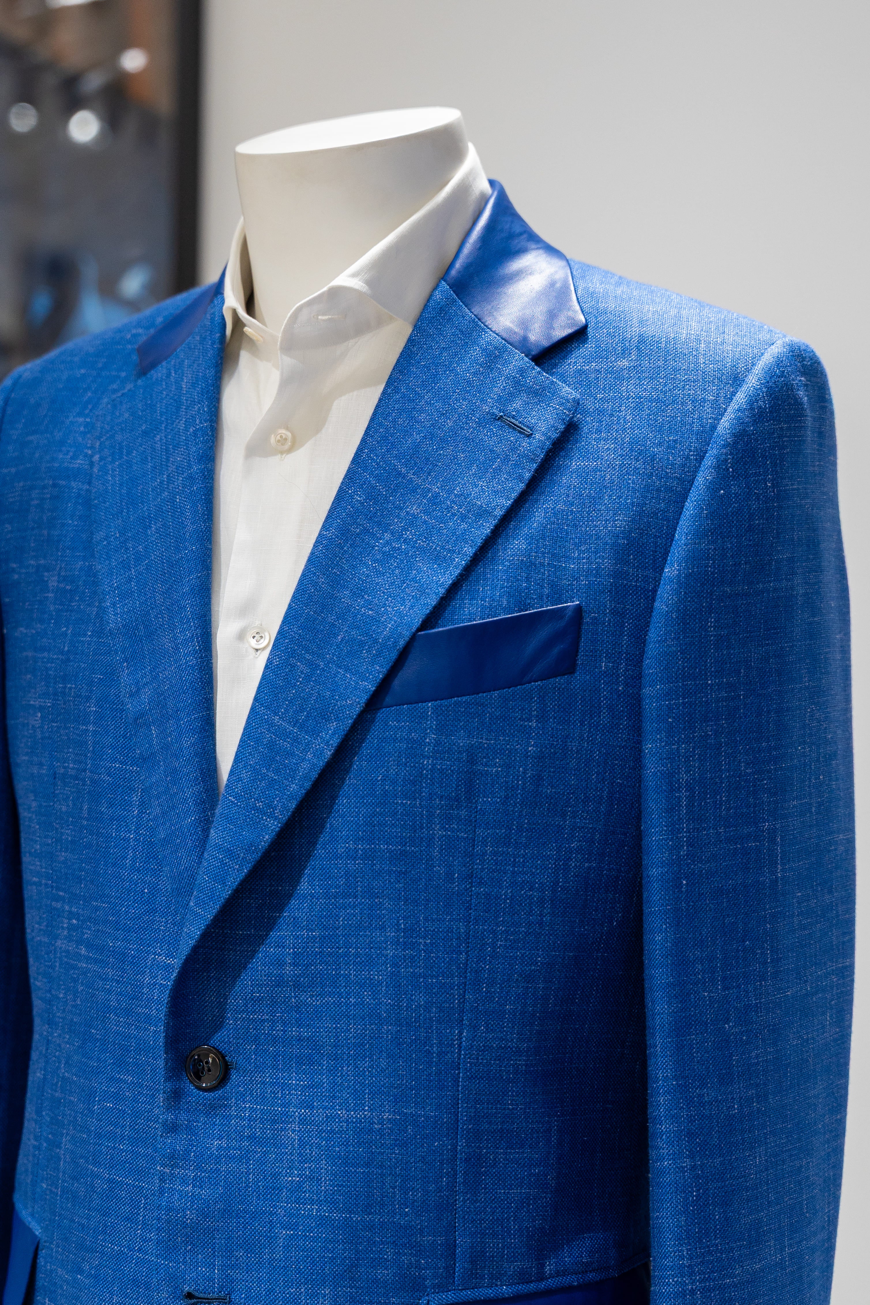 Blue suit jacket on a mannequin with a white shirt against a gray background. - Sartoia Dei-Duchi