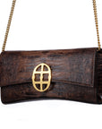 Brown embossed python skin clutch bag with gold chain and buckle/emblem on a white background. - DEI DUCHI (AMALTEA)