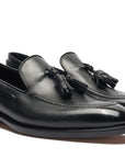 Pair of black loafers with a visible brand logo on a white background. Crust Calf. White full/grain calfskin. Tuscan tanned. Hand-dyed and antiqued leather. 9mm sole. 27mm heel height. Tuscan leather. Blake construction with bottom stitching. - Sartoria Dei Duchi - Atri