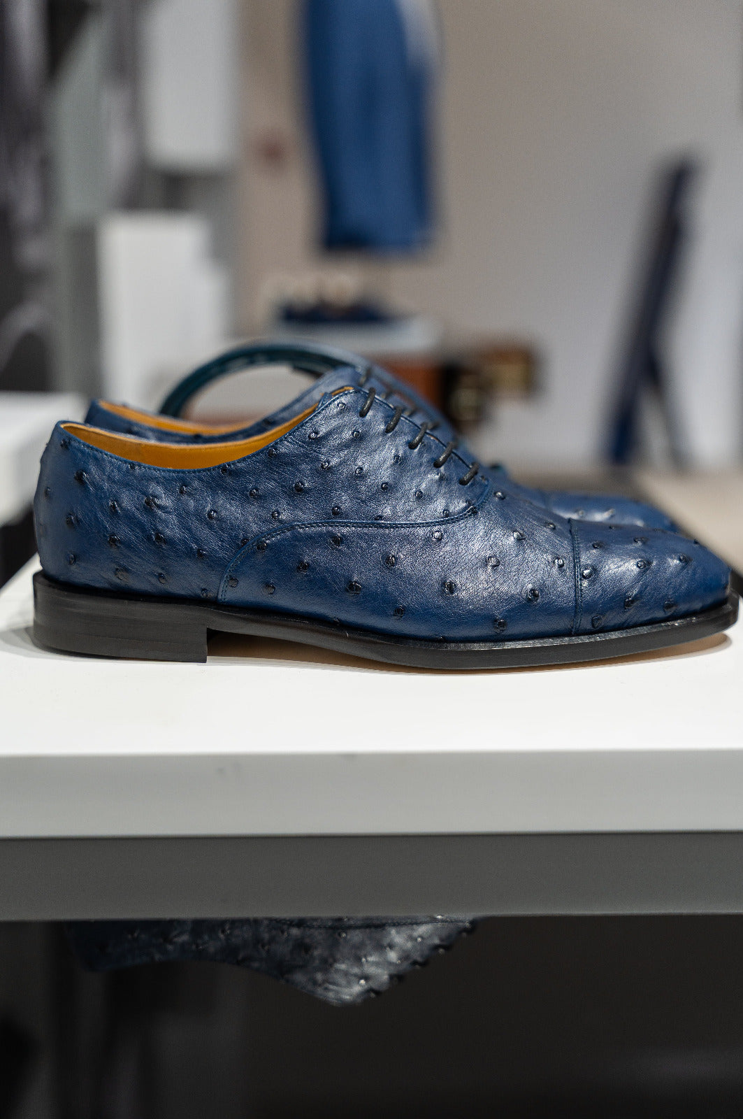 Blue textured dress shoe on a white surface with a blurred background. Sartoria Dei Duchi-Atri