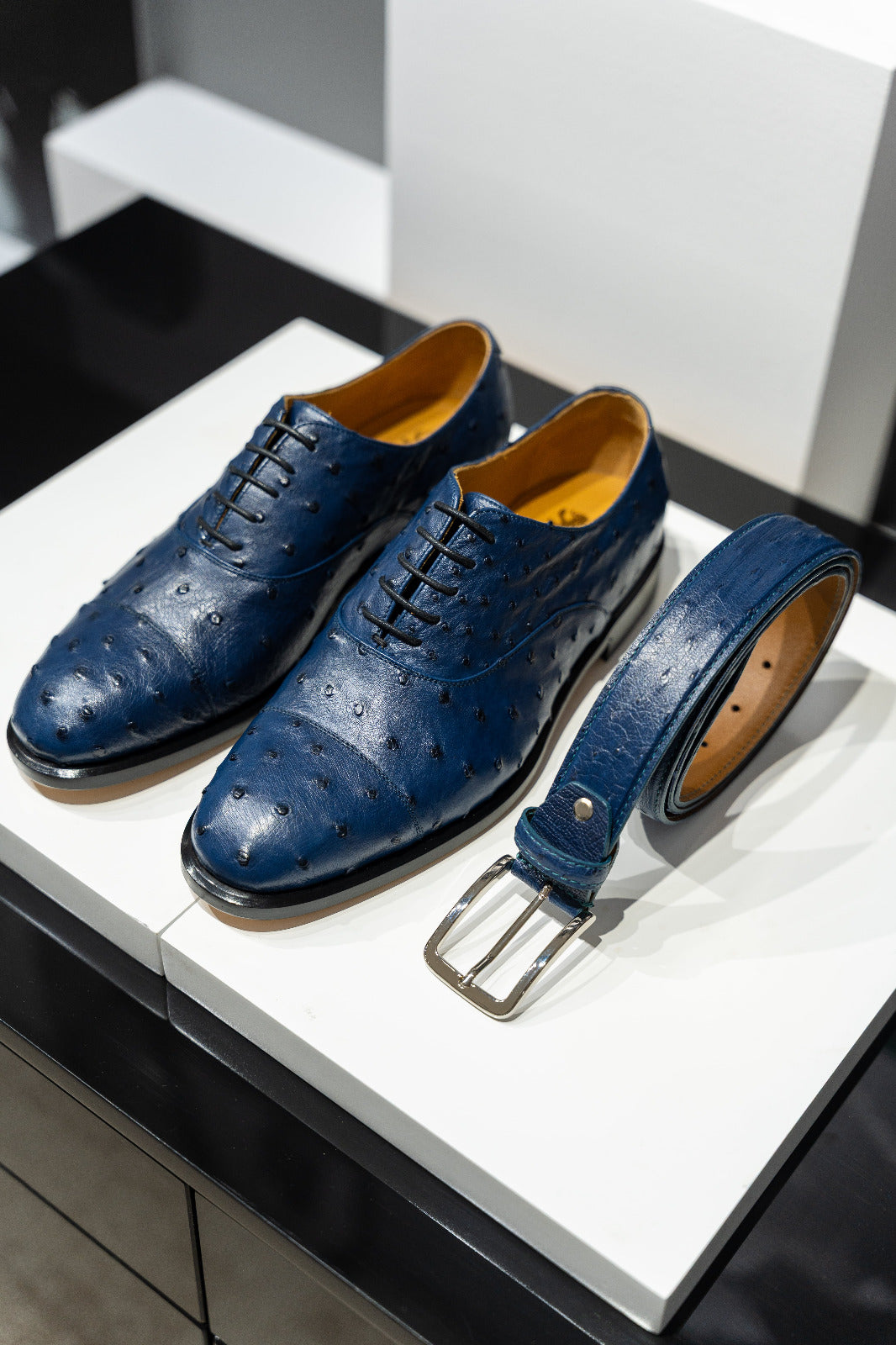 Blue dress shoes with a matching belt on a white surface.  - Sartoria Dei Duchi-Atri