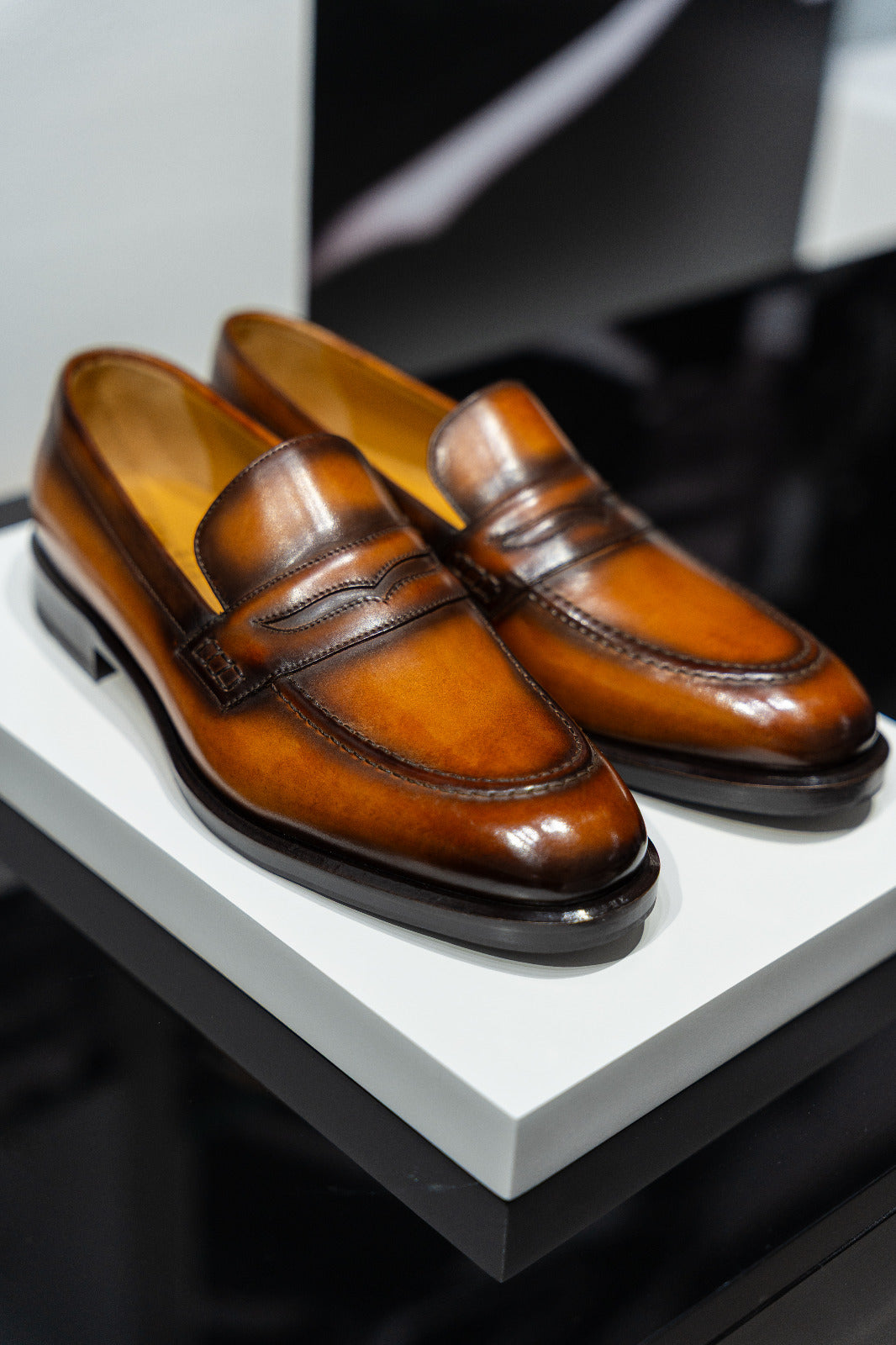 Pair of brown leather loafers on a white platform. - Sartoria Dei Duchi-Atri