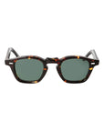Sunglasses with tortoiseshell frame and green lenses on a light gray background. - Dei Duchi