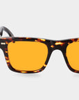 Sunglasses with tortoiseshell frame and orange lenses on a light gray background. - DEI DUCHI