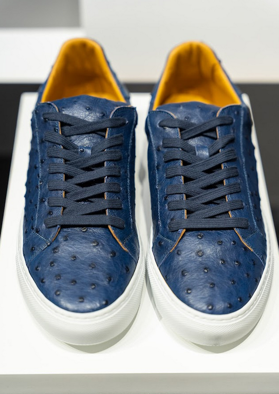 Pair of blue sneakers with white soles on a white surface. - Sartoria Dei Duchi-Atri