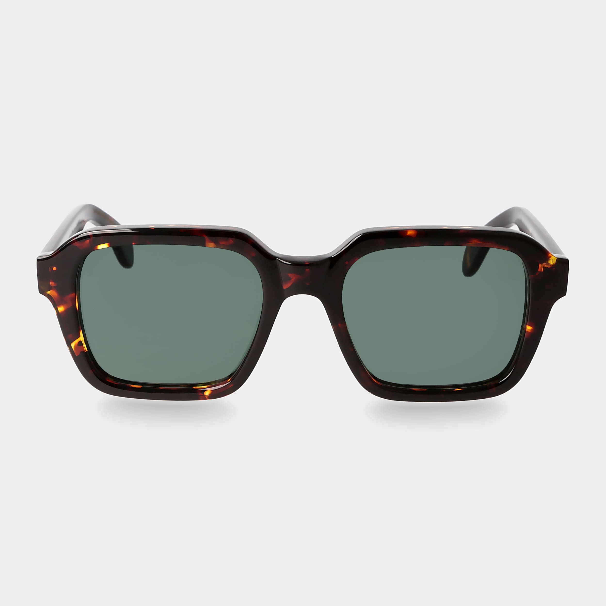 Sunglasses with tortoiseshell frame and green lenses on a light gray background. _ DEI DUCHI