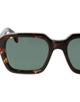 Sunglasses with tortoiseshell frame and green lenses on a light gray background. _ DEI DUCHI