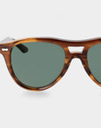 Sunglasses with tortoiseshell frame and green lenses on a light gray background. - DEI DUCHI