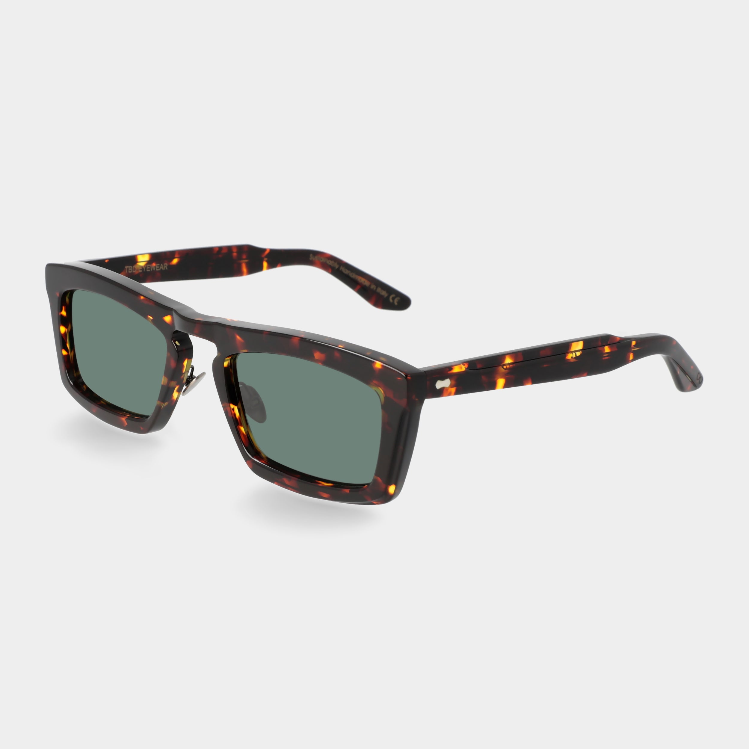 Sunglasses with tortoiseshell frame and green lenses on a light gray background. - De Duchi