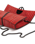 Red handbag with a chain detail, Red clutch bag with a gold emblem on a white background - DEI DUCHI (ALMATEA)