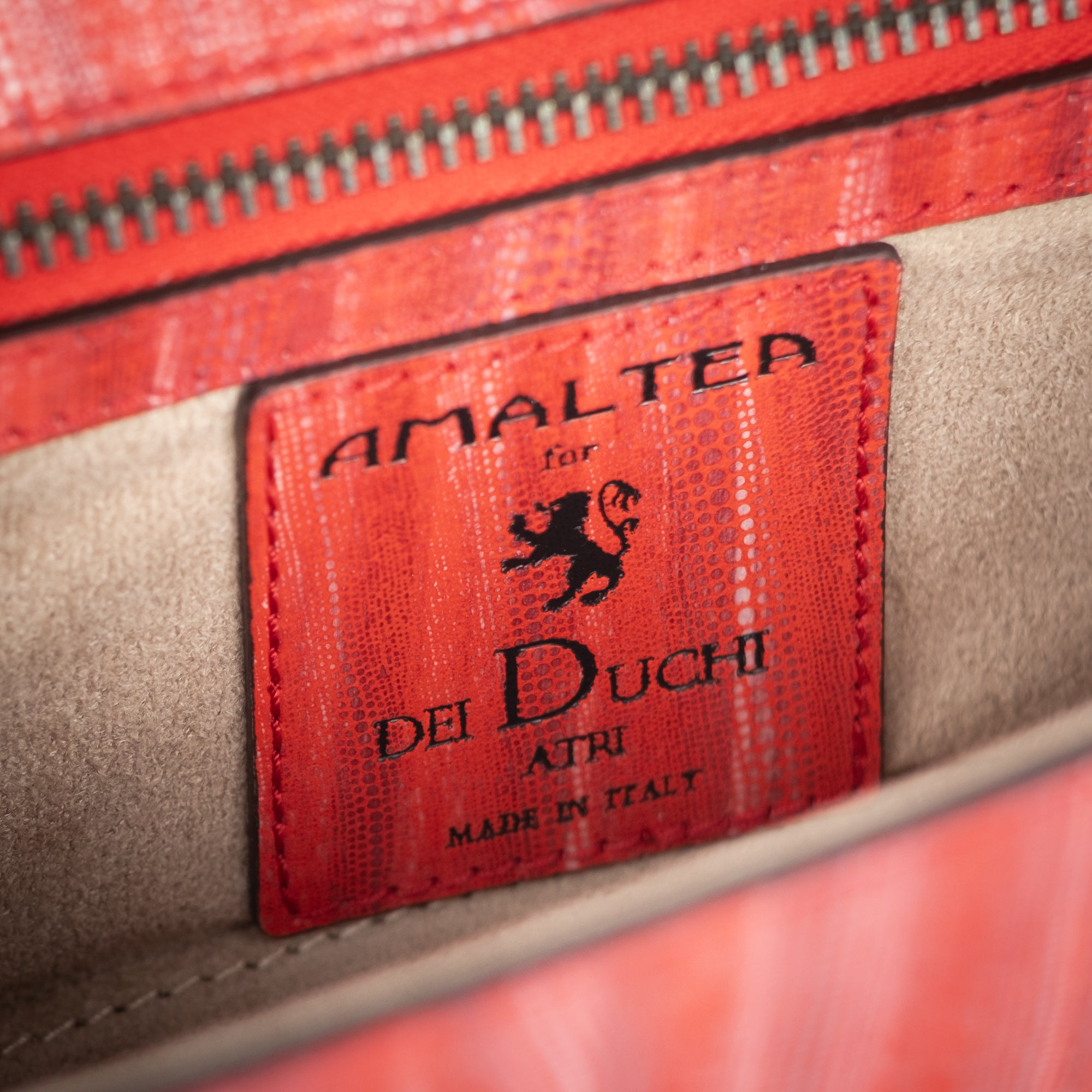 Red handbag with a chain detail, Red clutch bag with a gold emblem on a white background - DEI DUCHI (ALMATEA)