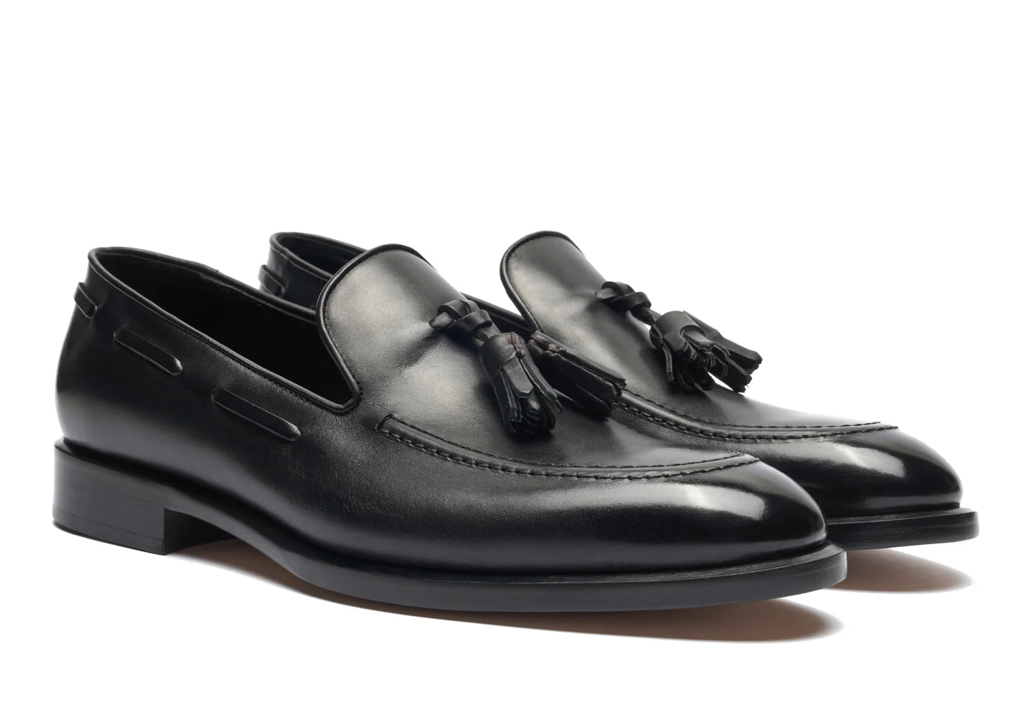 Pair of black loafers with a visible brand logo on a white background. Crust Calf. White full/grain calfskin. Tuscan tanned. Hand-dyed and antiqued leather. 9mm sole. 27mm heel height. Tuscan leather. Blake construction with bottom stitching. - Sartoria Dei Duchi - Atri