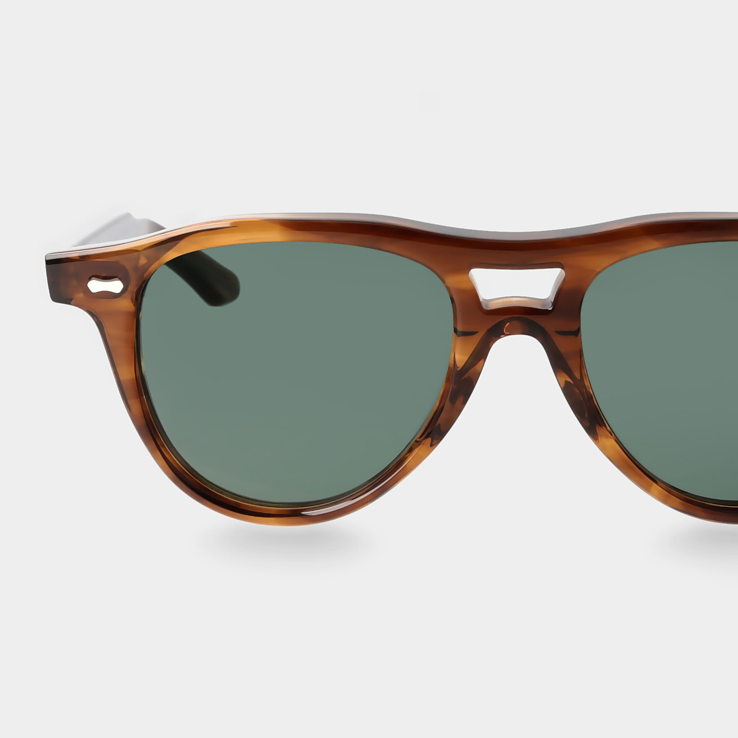 Sunglasses with tortoiseshell frame and green lenses on a light gray background. - DEI DUCHI