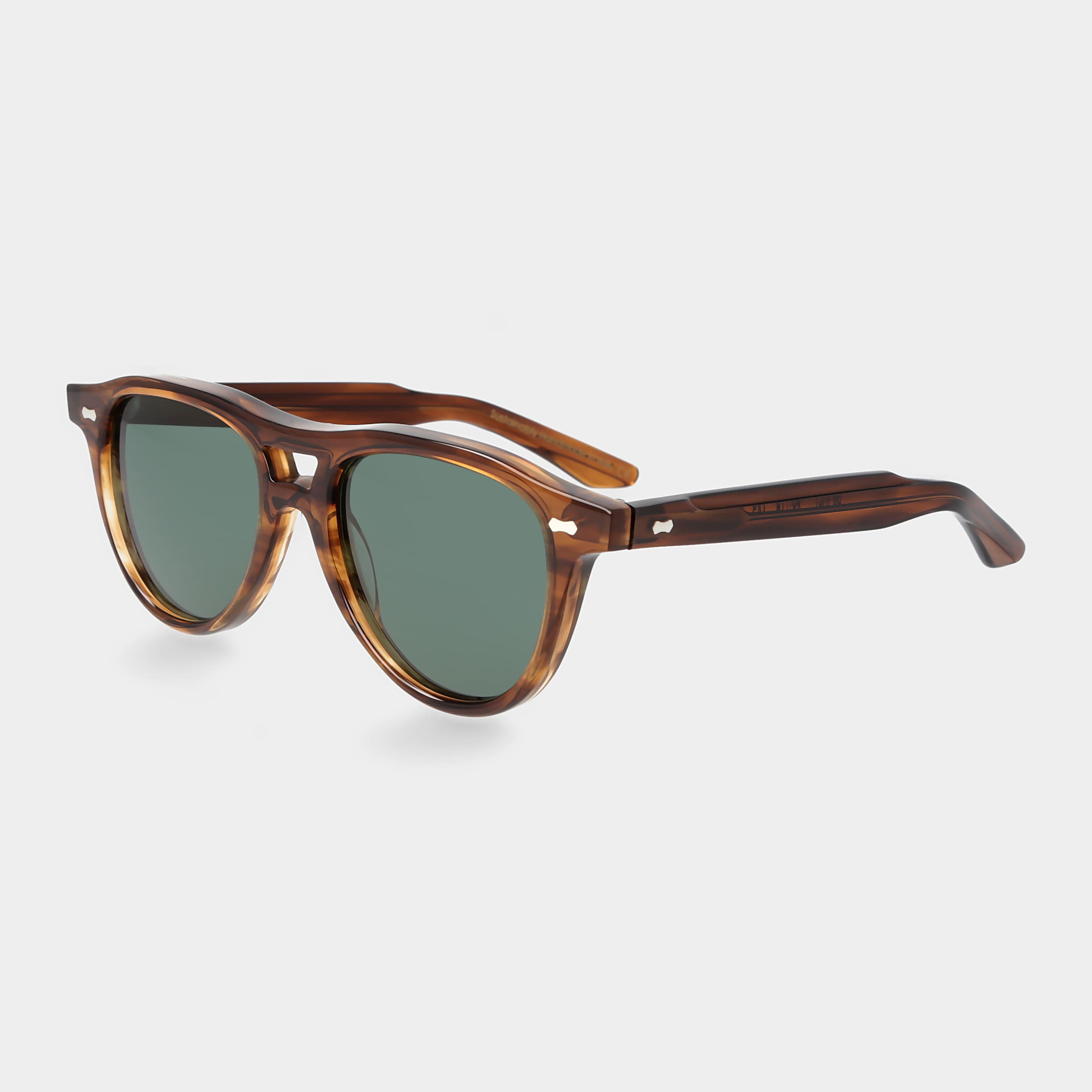 Sunglasses with tortoiseshell frame and green lenses on a light gray background. - DEI DUCHI