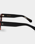 Sunglasses with tortoiseshell frame and dark lenses on a white background. - DEI DUCHI