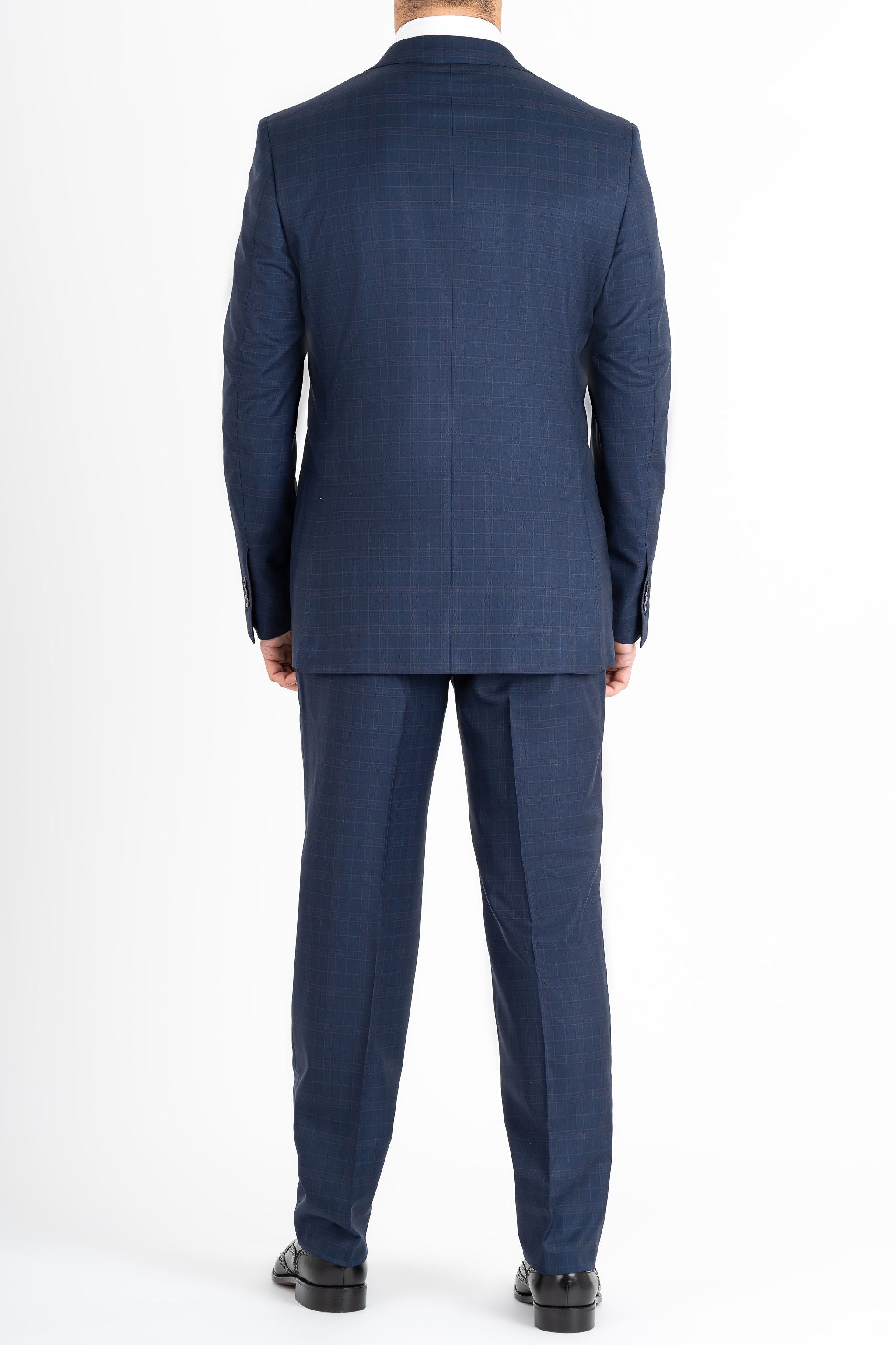 This Sartoria dei Duchi suit is made with a Caccioppoli 150s fabric made with 96% wool and 4% of Cashmere. The fabric has a midnight blue and light brown checked pattern. The jacket is fully lined and is made with two buttons, flap pockets and classic lapel. Pants are made without pleats, with American style pockets and comfortable no- slip belt loops. Side stitching on jacket and trousers.