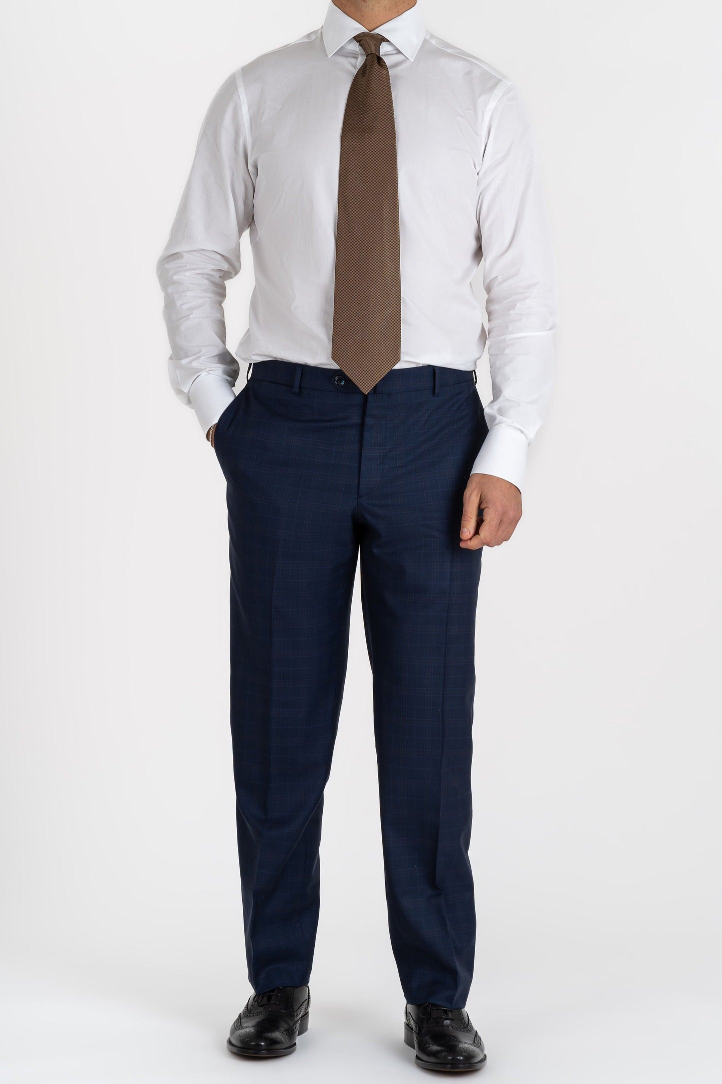 This Sartoria dei Duchi suit is made with a Caccioppoli 150s fabric made with 96% wool and 4% of Cashmere. The fabric has a midnight blue and light brown checked pattern. The jacket is fully lined and is made with two buttons, flap pockets and classic lapel. Pants are made without pleats, with American style pockets and comfortable no- slip belt loops. Side stitching on jacket and trousers.