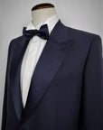 THE JACKET: Single-breasted jacket with one button. Peak lapel in silk satin. Classic pockets. Buttons lined in silk satin, double slit on the back. Button holes, pockets, undercollar and all finishing touches, are handmade by Italian tailors, with the sweet touch of a blue bow-tie.The TROUSER: not the usual classic silk satin band, but a Trouser that have a Silk satin belt,instead. Without pleats, slim, with internal buttons for suspenders.Also available in black color.|Sartoria Dei Duchi-Atri
