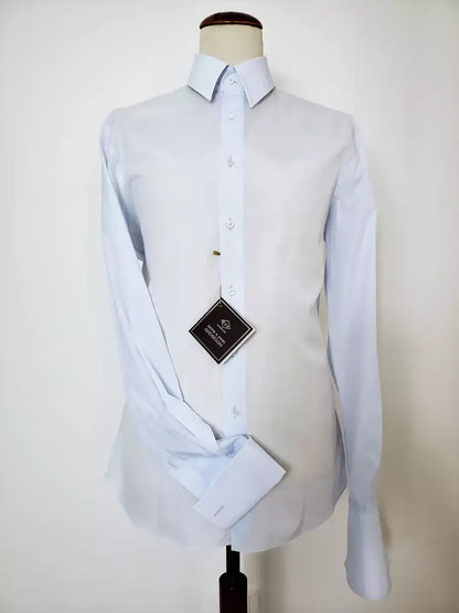Classic light blue shirt in 100% pure Giza 45 cotton poplin by D&J Anderson. Italian collar w/ internal sticks. Double cuffs, height: 7 cm Hand-sewn VICTORIA FLAT WHITE PEARL buttons. 0.5 mm topstitch on the collar and cuffs - plain front - pleats on the back - bottom hem in margin. Mouches branded D&J Anderson. Fabric: 100% D&J Anderson "Popeline 240 warp", precious poplin made w/ the best cotton in the world (Egyptian cotton Giza 45) |Sartoria Dei Duchi-Atri