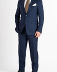This Sartoria dei Duchi suit is made with a Caccioppoli 150s fabric made with 96% wool and 4% of Cashmere. The fabric has a midnight blue and light brown checked pattern. The jacket is fully lined and is made with two buttons, flap pockets and classic lapel. Pants are made without pleats, with American style pockets and comfortable no- slip belt loops. Side stitching on jacket and trousers.